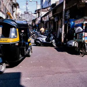 Auto rickshaw running street corner