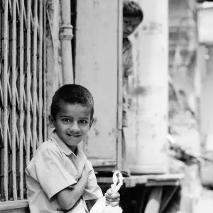 A boy on the roadside and a boy looking behind him