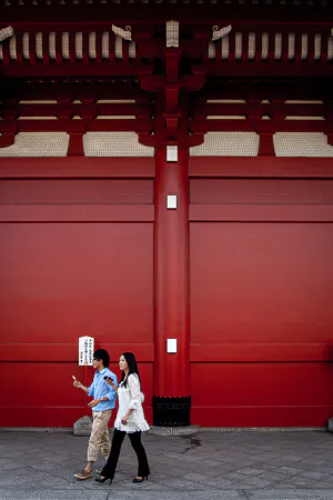 浅草寺の宝蔵門横を歩く若いカップル