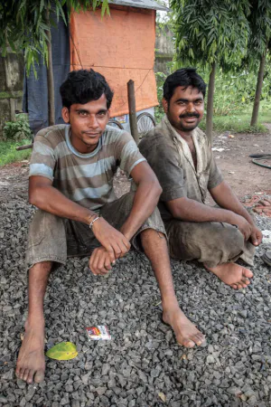 Men sitting on gravel