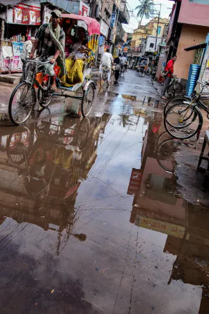 Cycle rickshaw going through a puddle