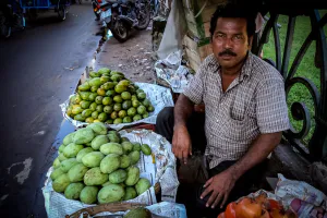 Man selling mango and pomegranate on the side of the road