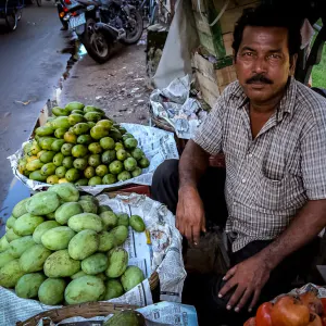 道端でマンゴーと柘榴を売る男