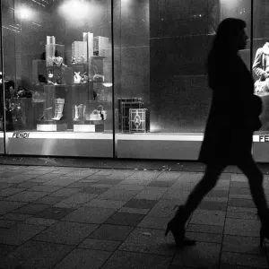 woman in high heels walking in front of a show window