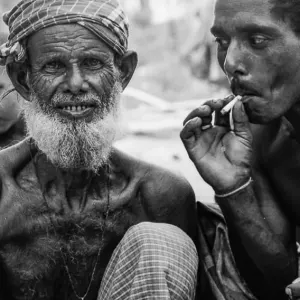 微笑む老人と煙草を吸う男