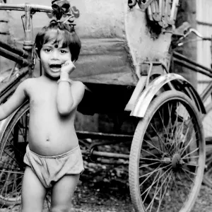 Little girl beside cycle rickshaw