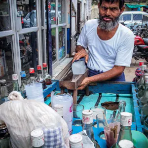 Man at a food stall selling juice shaving ice