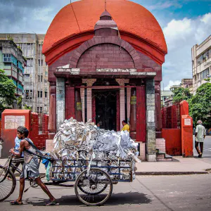 Tricycle with luggage carrier in front of Hindu hall