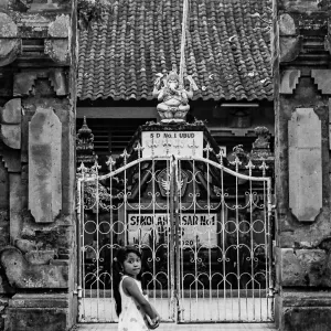 Girl walking in front of gate of school