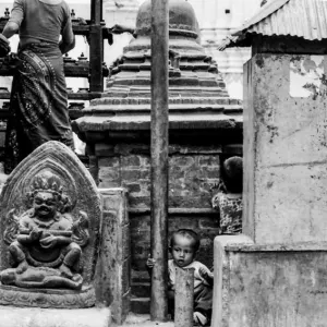Boy playing among Buddha images