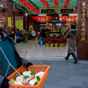 台灣省城隍廟でお供え物を売る男