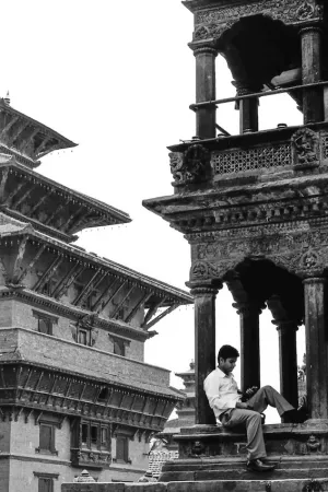 Man relaxing under the eaves of the Krishna Temple
