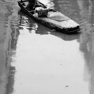Man rowing a boat on a waterway in Suzhou