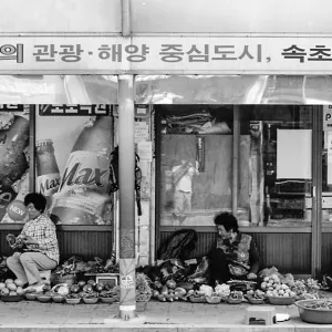 Woman selling vegetables on the sidewalk