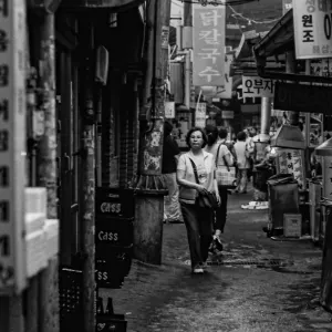 ゴミゴミした路地に立つ女