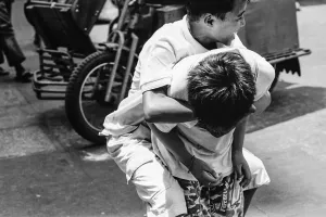 Boy holding onto boy tightly