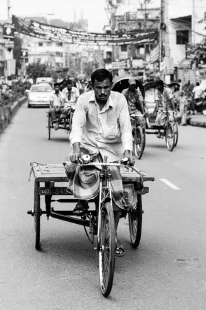 Man pedaling the tricycle with cart
