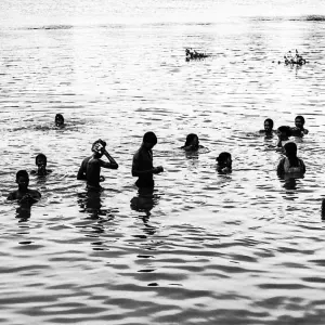 Silhouetted people soaking in Mahananda river