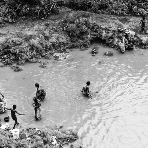 People standing in Mahananda River