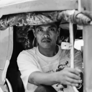 Man holding the handrail on Jeepney