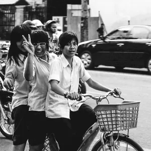 Three girls riding on same bicycle