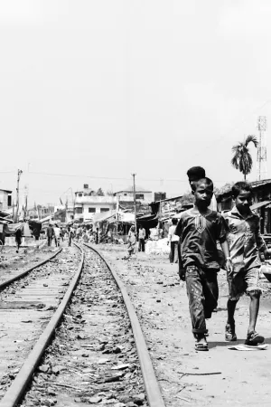 Boys walking beside rail track