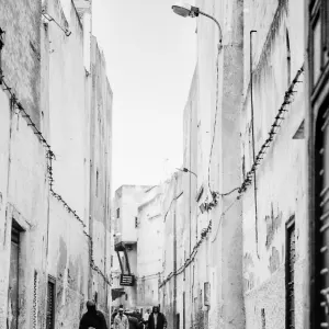 People walking alleyway without windows