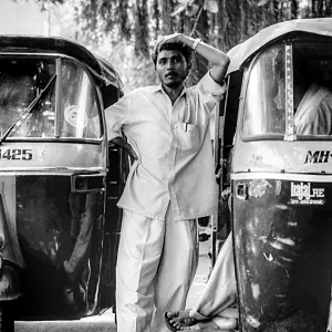 Man between auto rickshaws