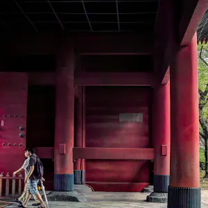 増上寺の赤い三解脱門の下を歩く参拝者たち