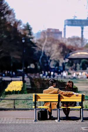 日比谷公園のベンチに腰掛けたカップル