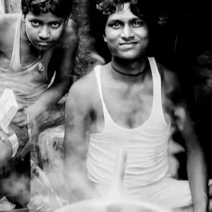 Men working at a chai stand and a steamy pot