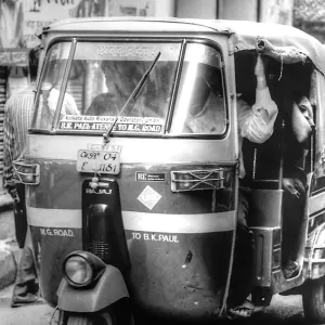 Auto rickshaw driving slowly down an alley