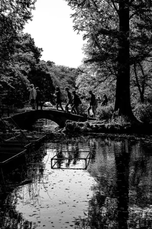 Silhouettes crossing a small stone bridge in Inokashira Park