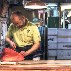Man cutting tuna block