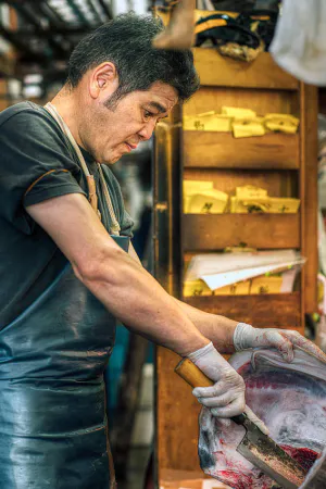 Man cutting head of tuna