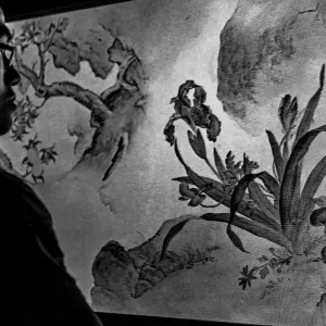 Man looking at an ink brush painting on the screen